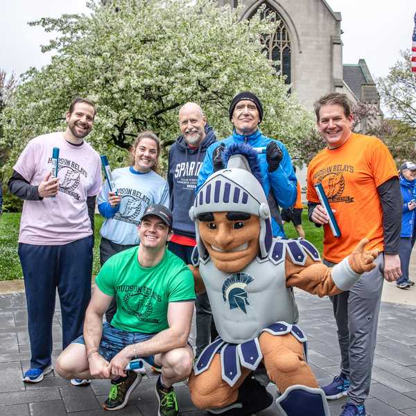 A group of six Hudson Relays runners posing with CWRU’s mascot, Spartie.