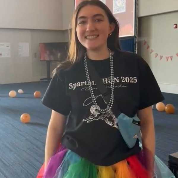 A CWRU student poses in a rainbow-colored tutu at the Spartanthon fundraising event in Tinkham Veale University Center’s ballroom.