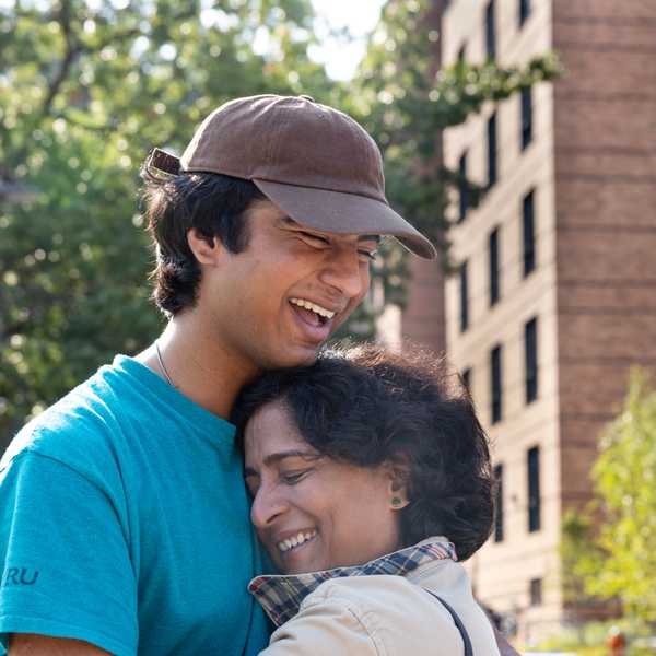 A CWRU student smiles and embraces a loved one during move-in day.