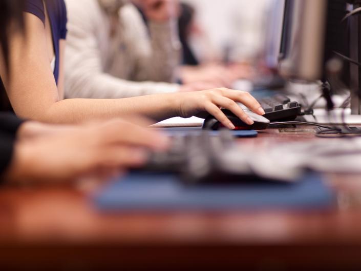 Side view of students using computers
