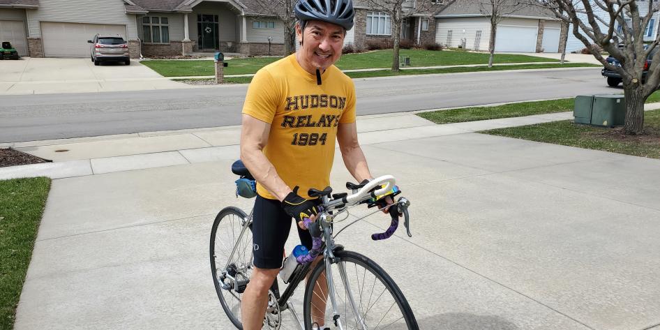 Man in a yellow shirt riding a bike