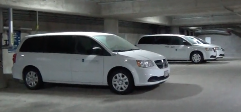 Image of three white vans in parking garage.