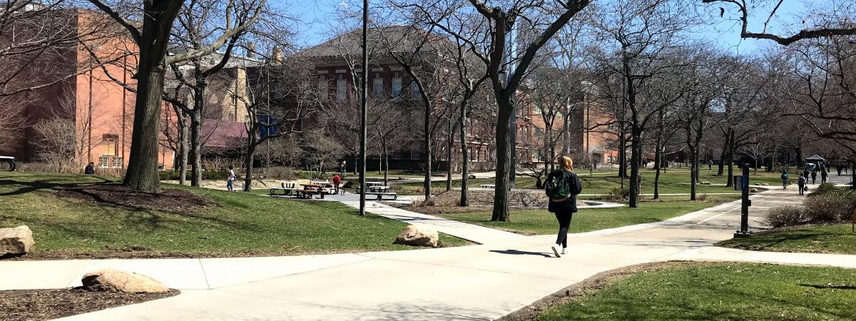 A college student walks across the Case Western Reserve University main quad in early spring