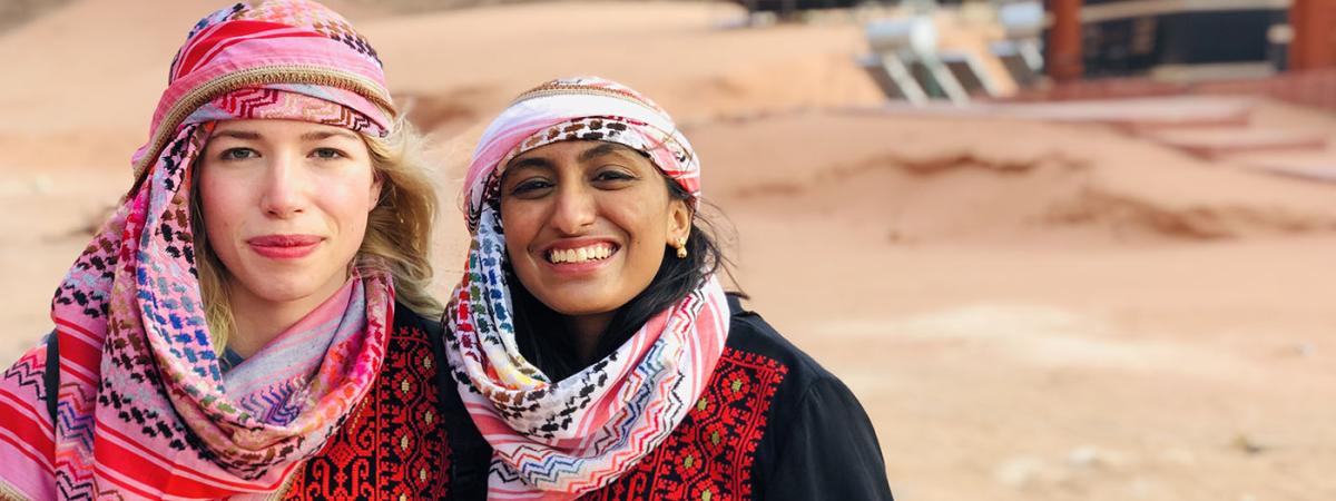 Photo of 2 Study Abroad Students in Bedouin Attire in Desert