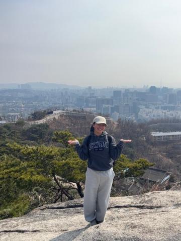 CWRU student hiking Ansan Mountain with Seoul, South Korea in the background