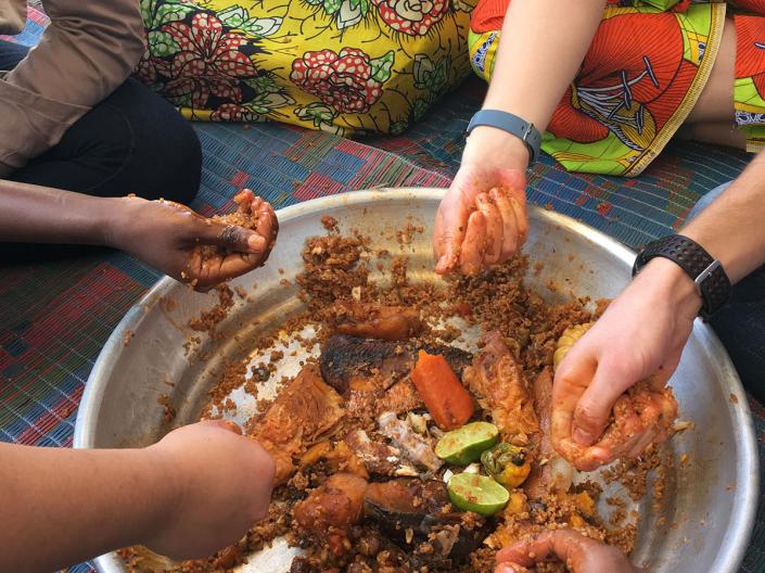 a circle of hands eating out of a food bowl
