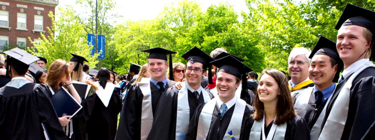 Large group of students wearing caps and gowns outside