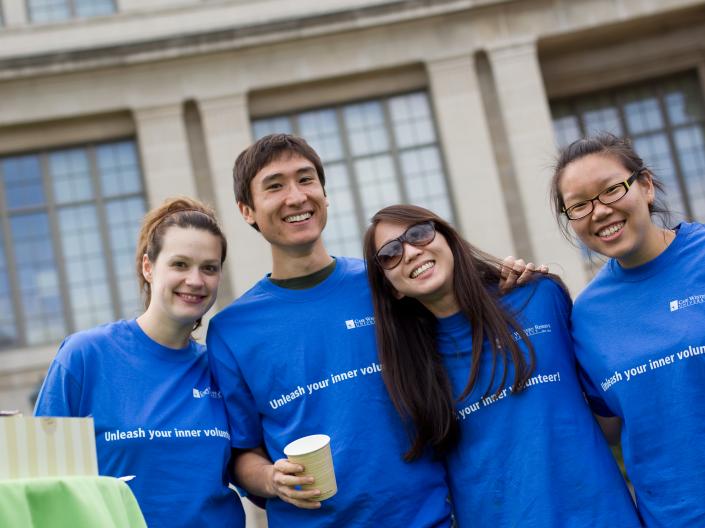 Four students smiling at the camera outside Kelvin Smith Library