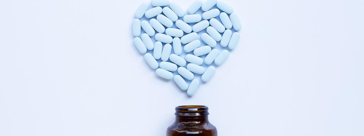 Bill pills in heart shape above a brown bottle