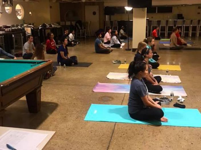 A group of students meditating on yoga mats