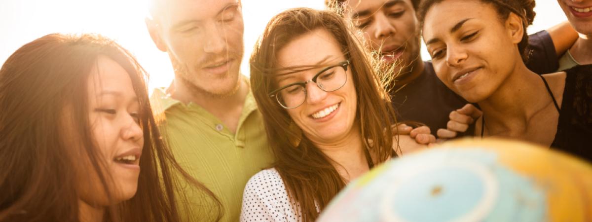 Group of college students around a globe