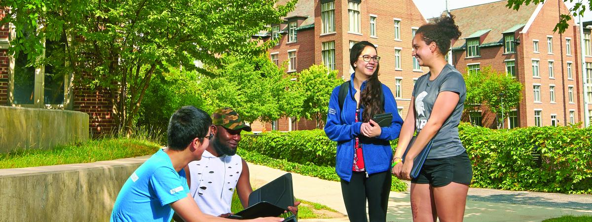 Students standing and talking outside residence halls