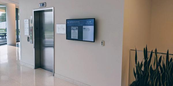 An infoboard display beside an elevator door in Tinkham Veale University Center at Case Western Reserve University