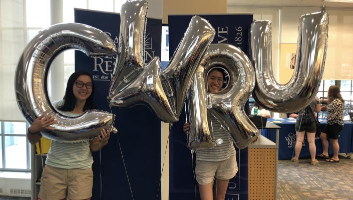Students holding "CWRU" letter balloons 