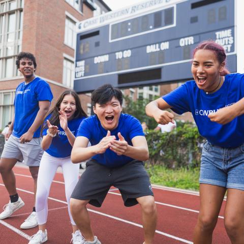 Students in blue CWRU shirts cheering outside