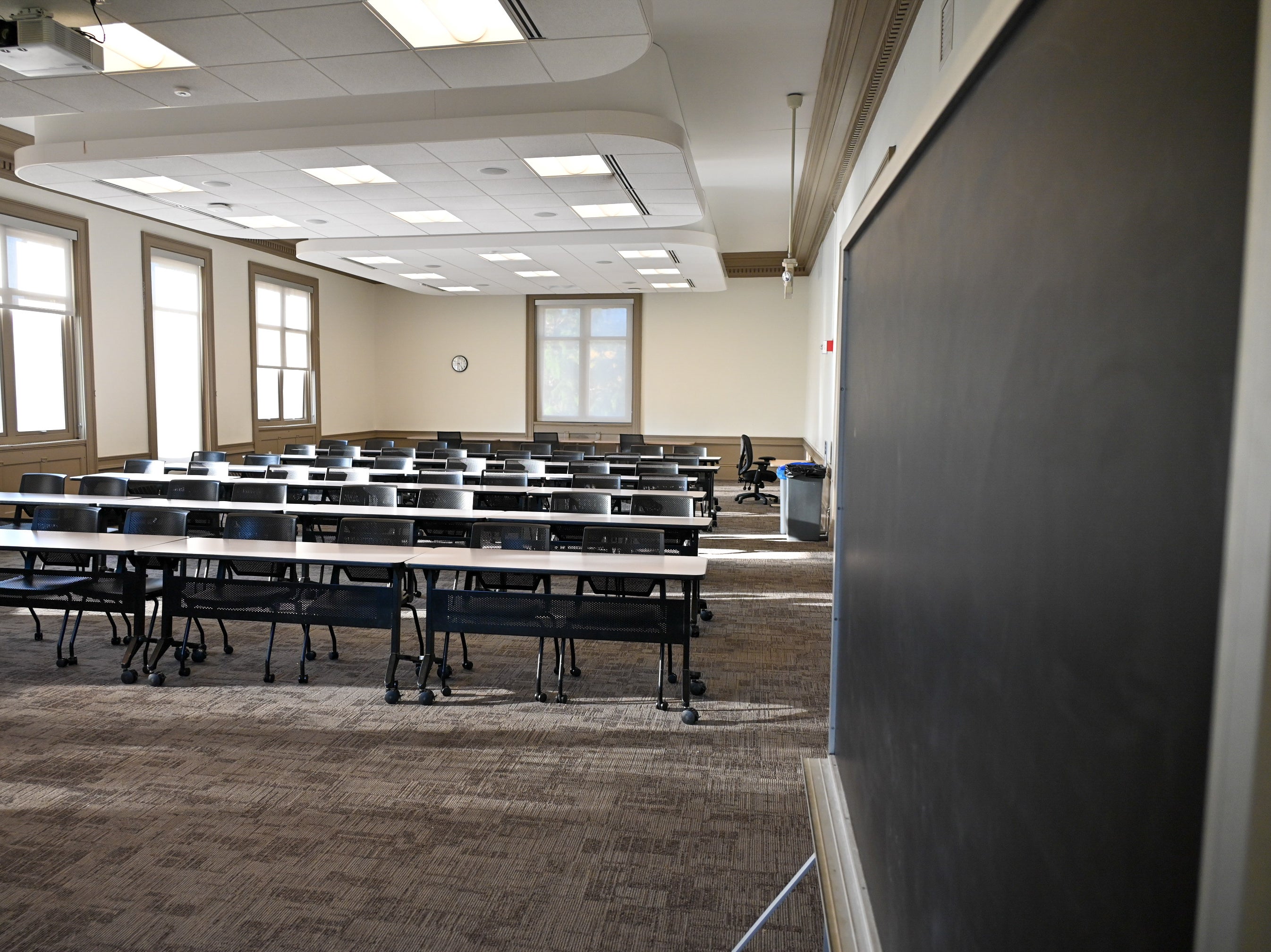 View of Room 201 in Thwing Center of classroom desks and chairs in rows with a blackboard on the right side