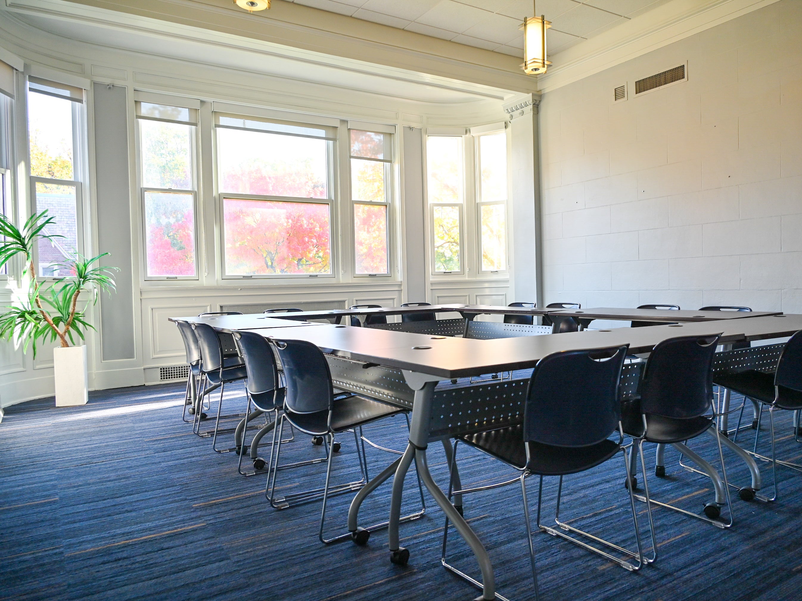 Empty Room 218 in Thwing Center with chairs around tables in a large hollow square