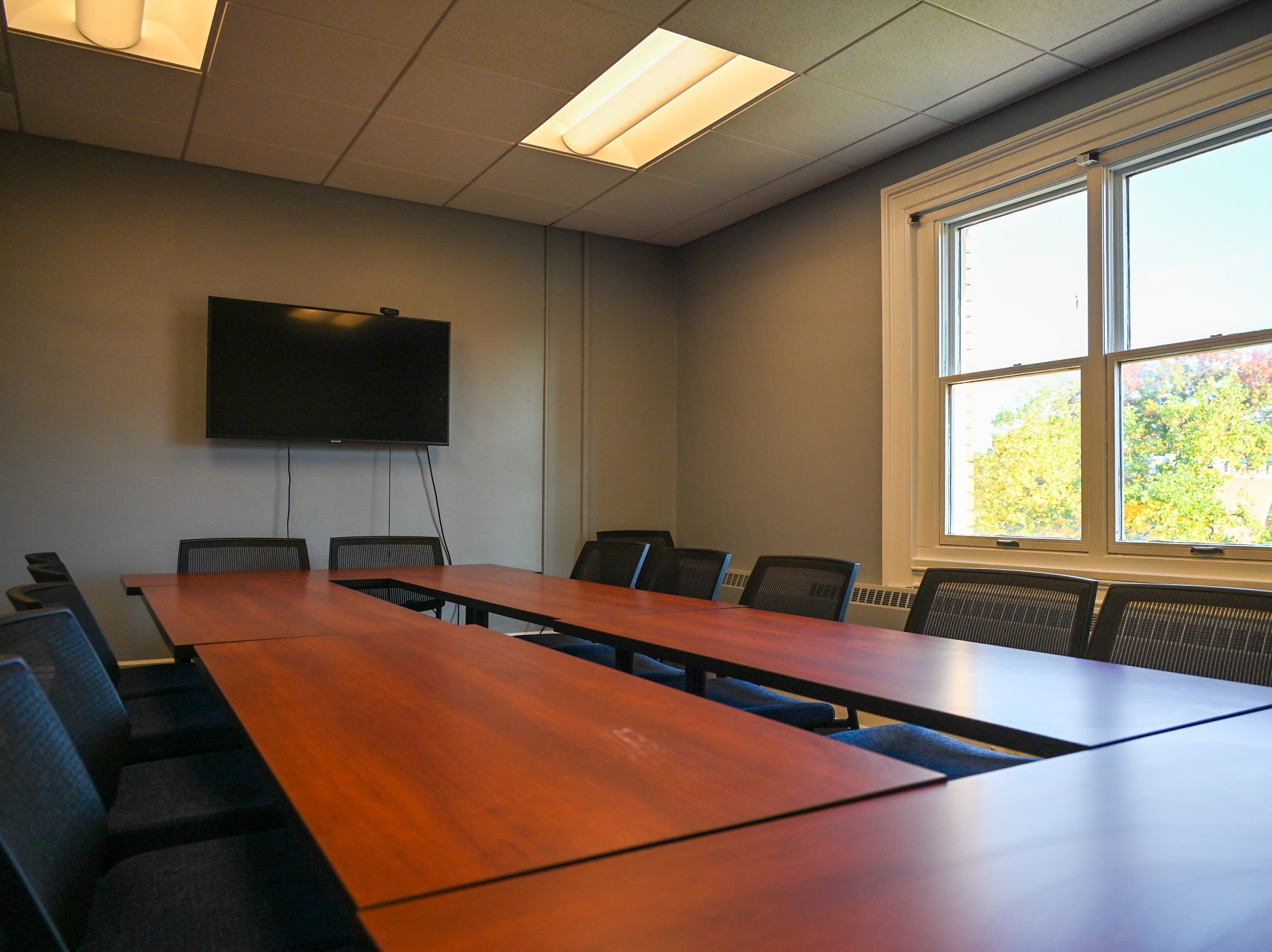 Empty small conference room with chairs around the central tables