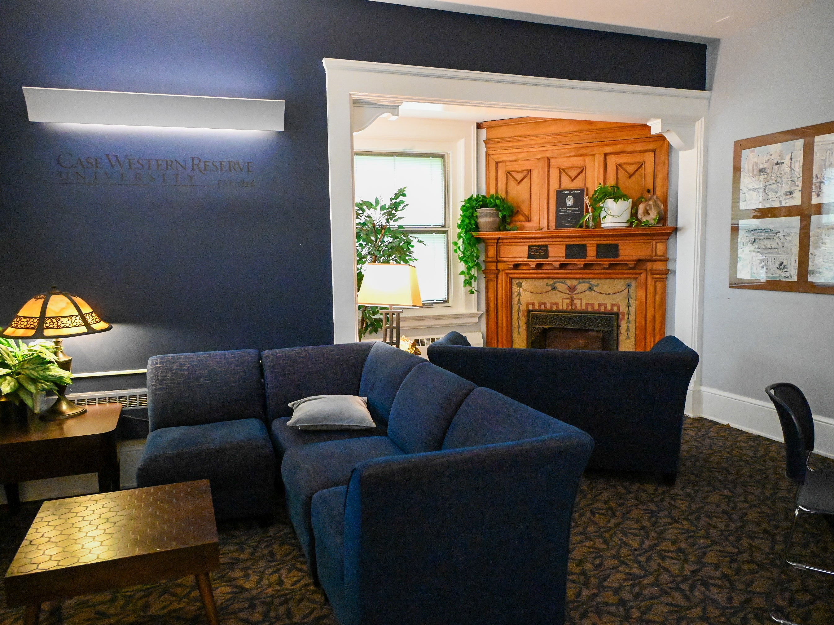 View of Spartan Room in Thwing Center, couches and lounge space with a historic fireplace mantel in the back