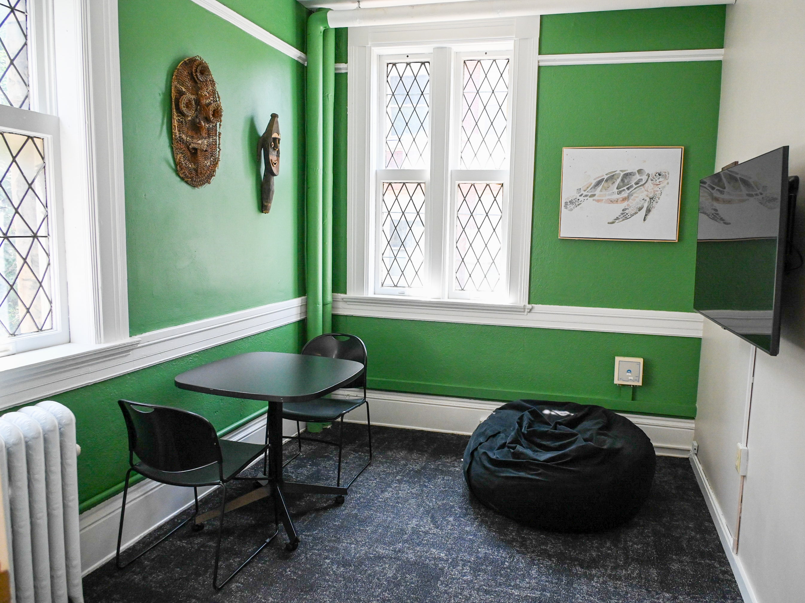 Small Study room with a table and chairs and a beanbag with green walls and décor highlighting Pacific Islander culture