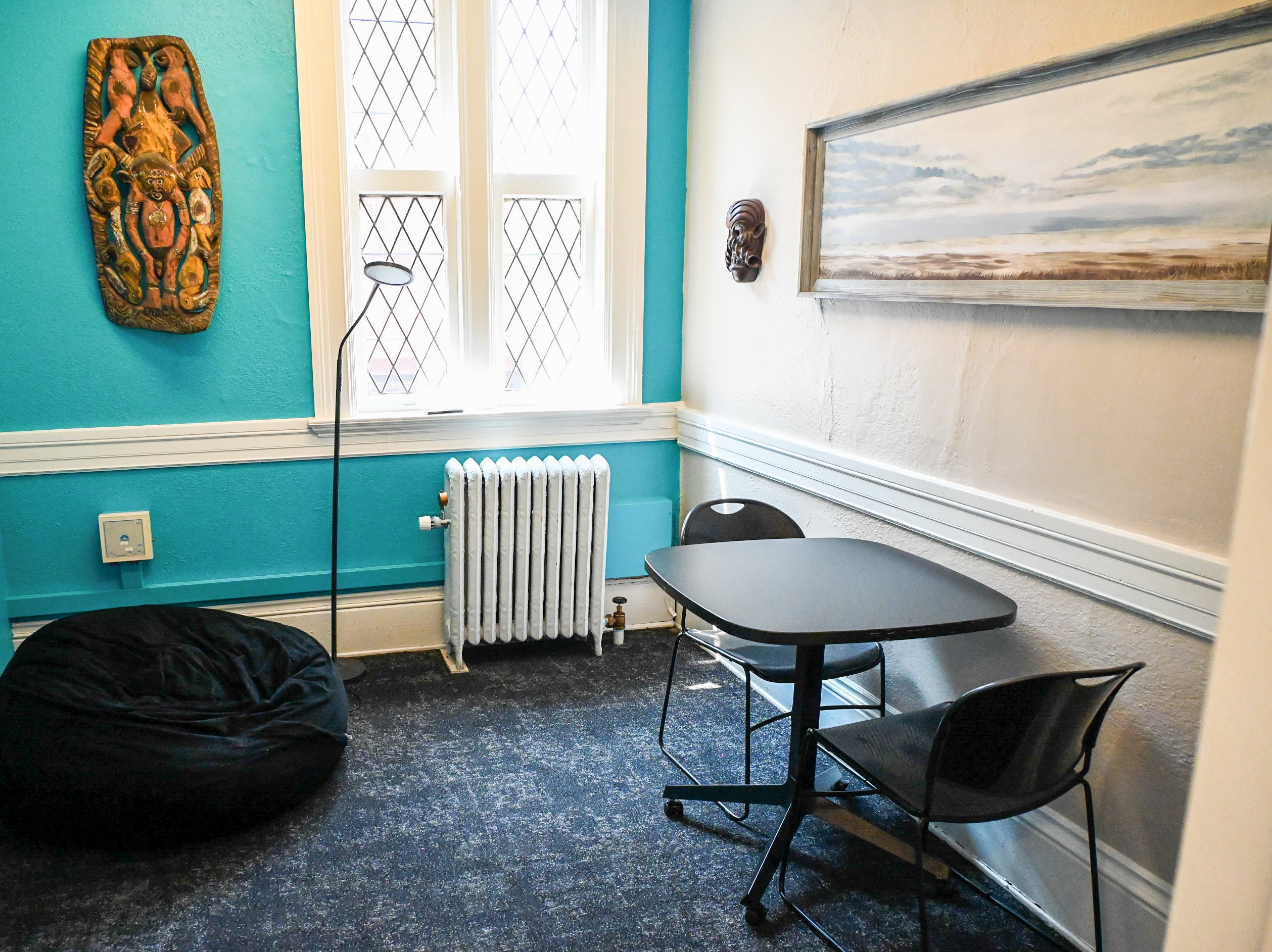 Small Study room with a table and chairs and a beanbag with bright blue walls and décor highlighting Pacific Islander culture