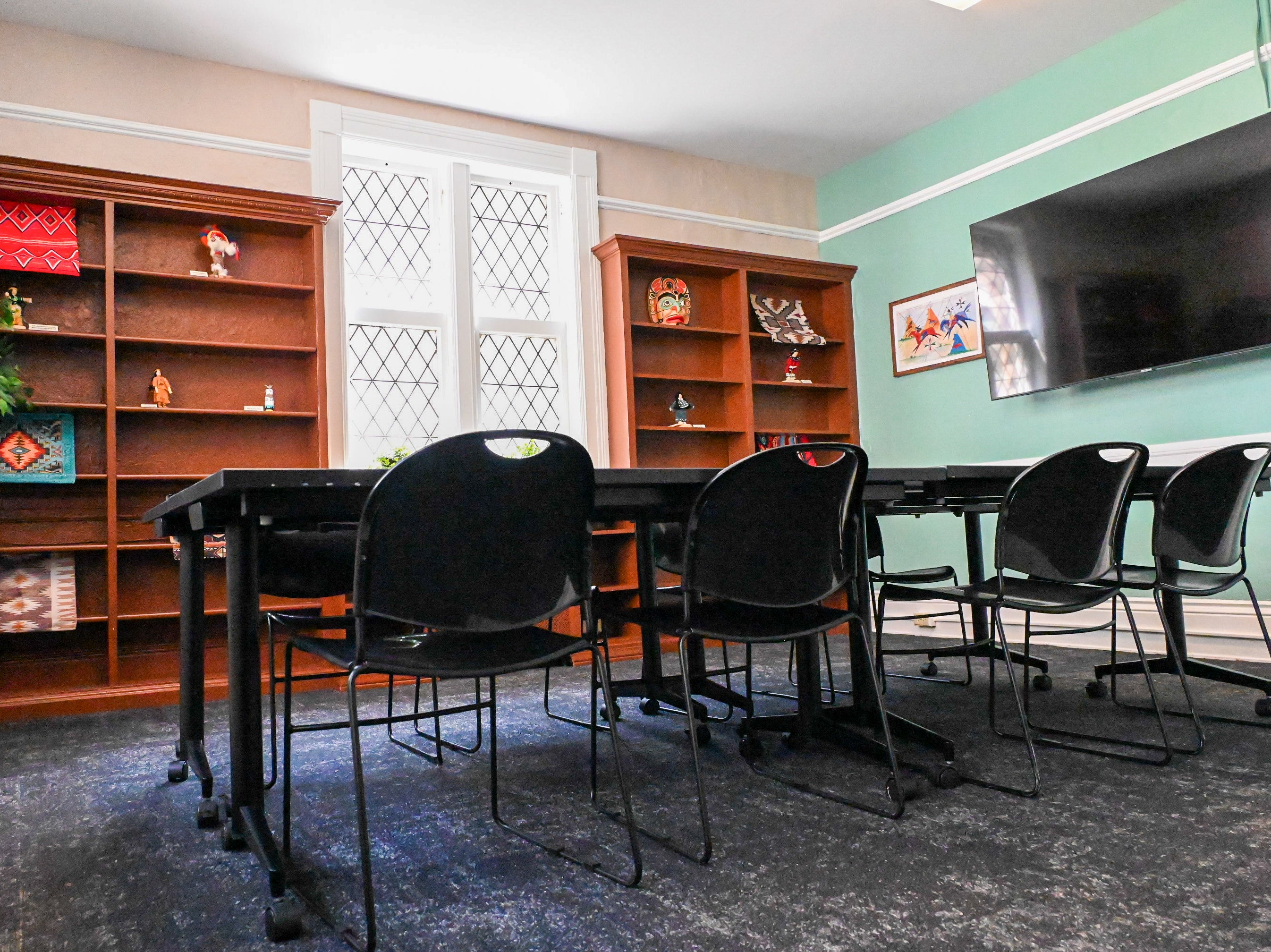 Meeting room with large bookcases and décor highlighting Indigenous American culture