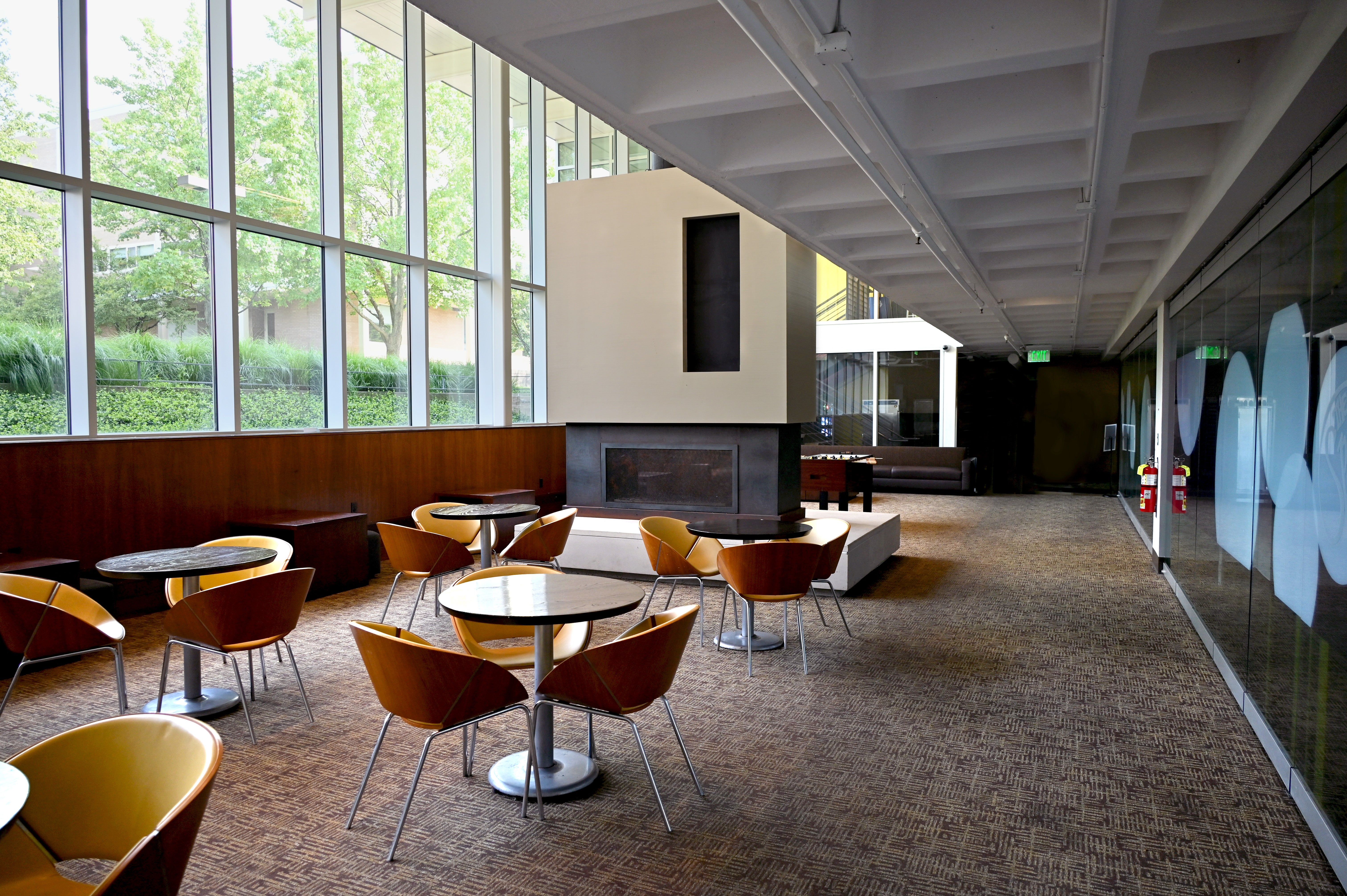 Fireplace Lounge with tables and large windows on the left