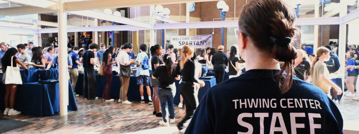 Student staffer looking out over a busy event in Thwing Atrium