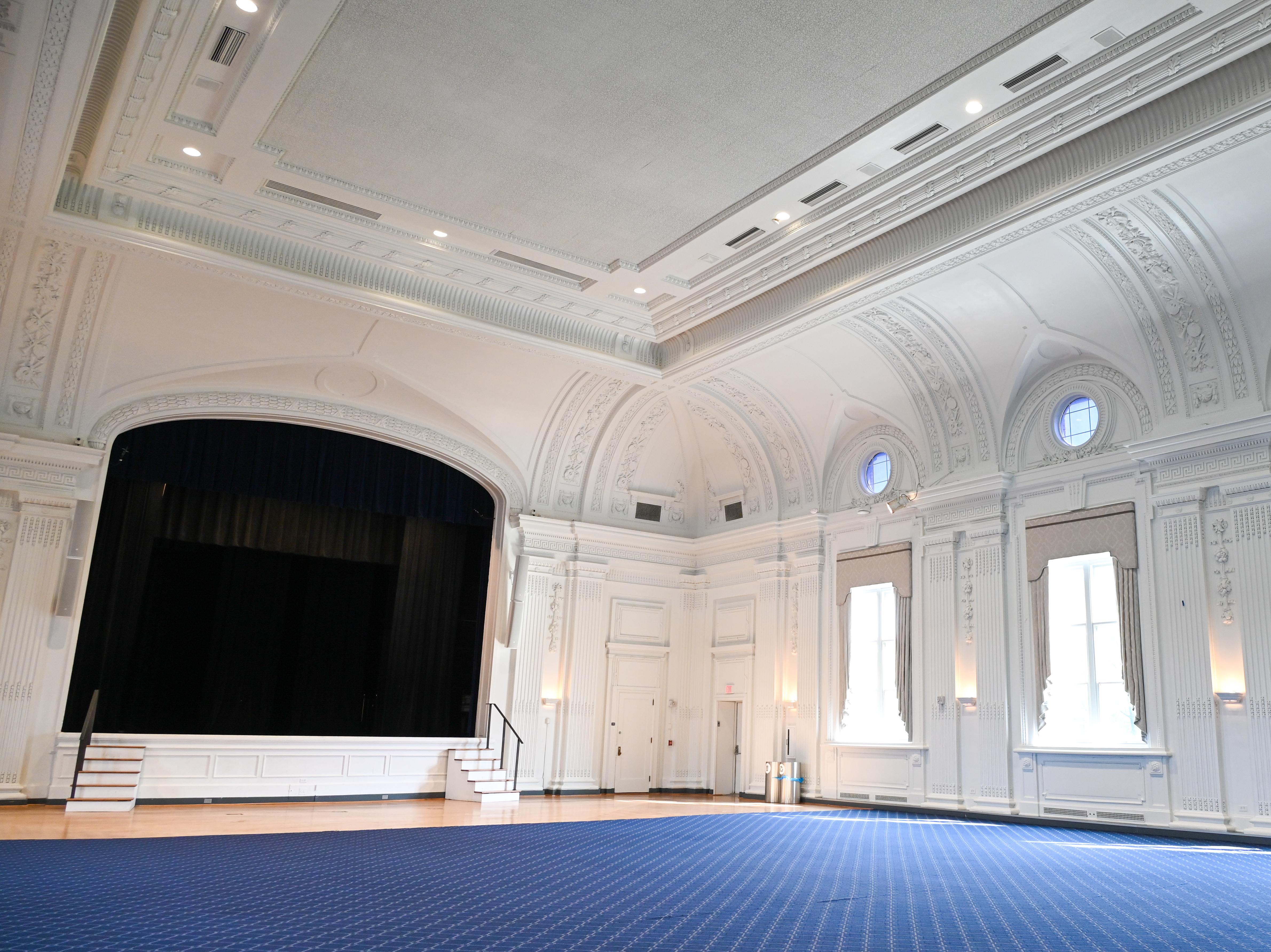 View of an empty Thwing Cent Ballroom facing the stage but tilting upward to be able to see the beautiful columns and molding around the room