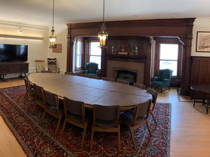 An empty view of the Cleveland Room with its large round conference table and a television.