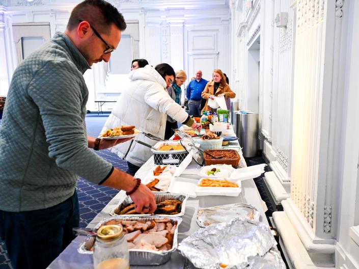 Guests pick up food from a buffet line