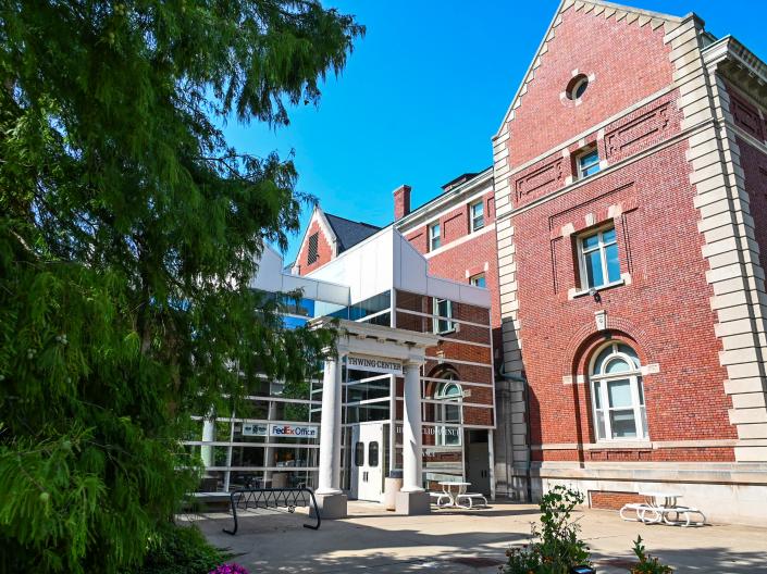 View of the front enterance of Thwing Center, the pillars out front are centered with a tree taking up the left third of the shot