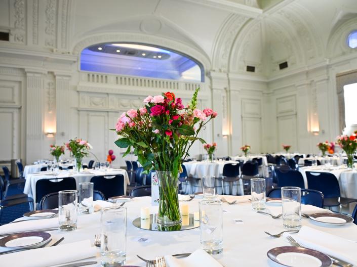 Table in Thwing Ballroom set with flowers as a centerpiece