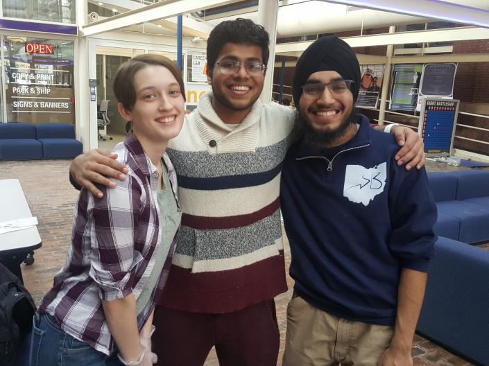 Three students standing together in the Thwing Atrium