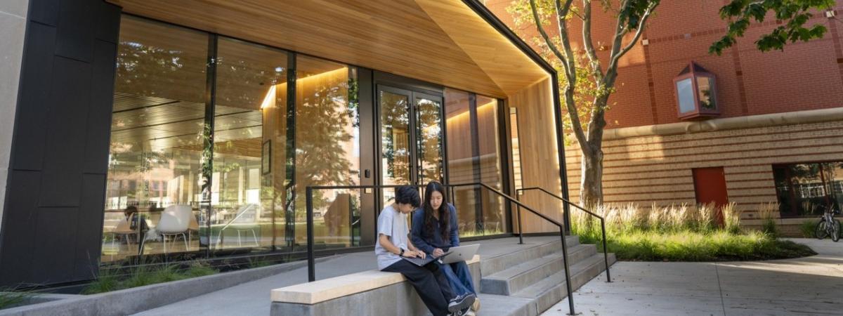 2 students working on a computer outside of Olin
