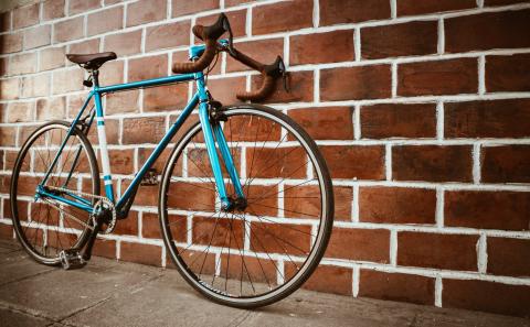 blue bike against red brick wall