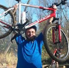 Tom Ligman holding up his bike