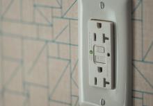 white electrical outlet on white and blue geometric wallpaper