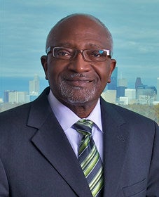 Robert Bullard in a suit with city in the background