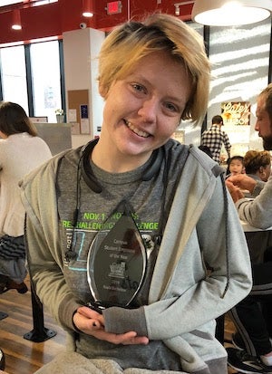 young woman with short, blond hair holding award