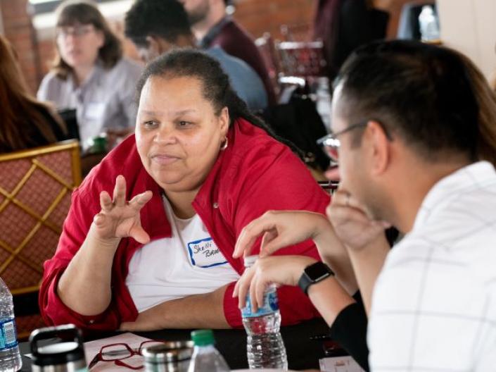 Participant speaking at table at Convening of Ideas + Action 