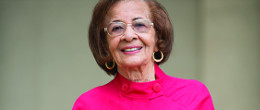 An older woman in a bright pink blouse.