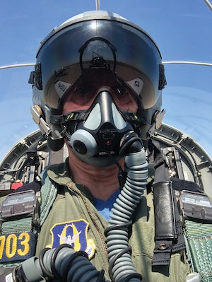 Case Western Reserve professor Michael Decker in an airplane wearing a helmet and oxygen mask