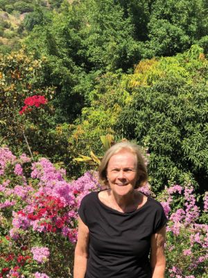 Cathy Strachan Lindenberg standing outdoors in front of flowers