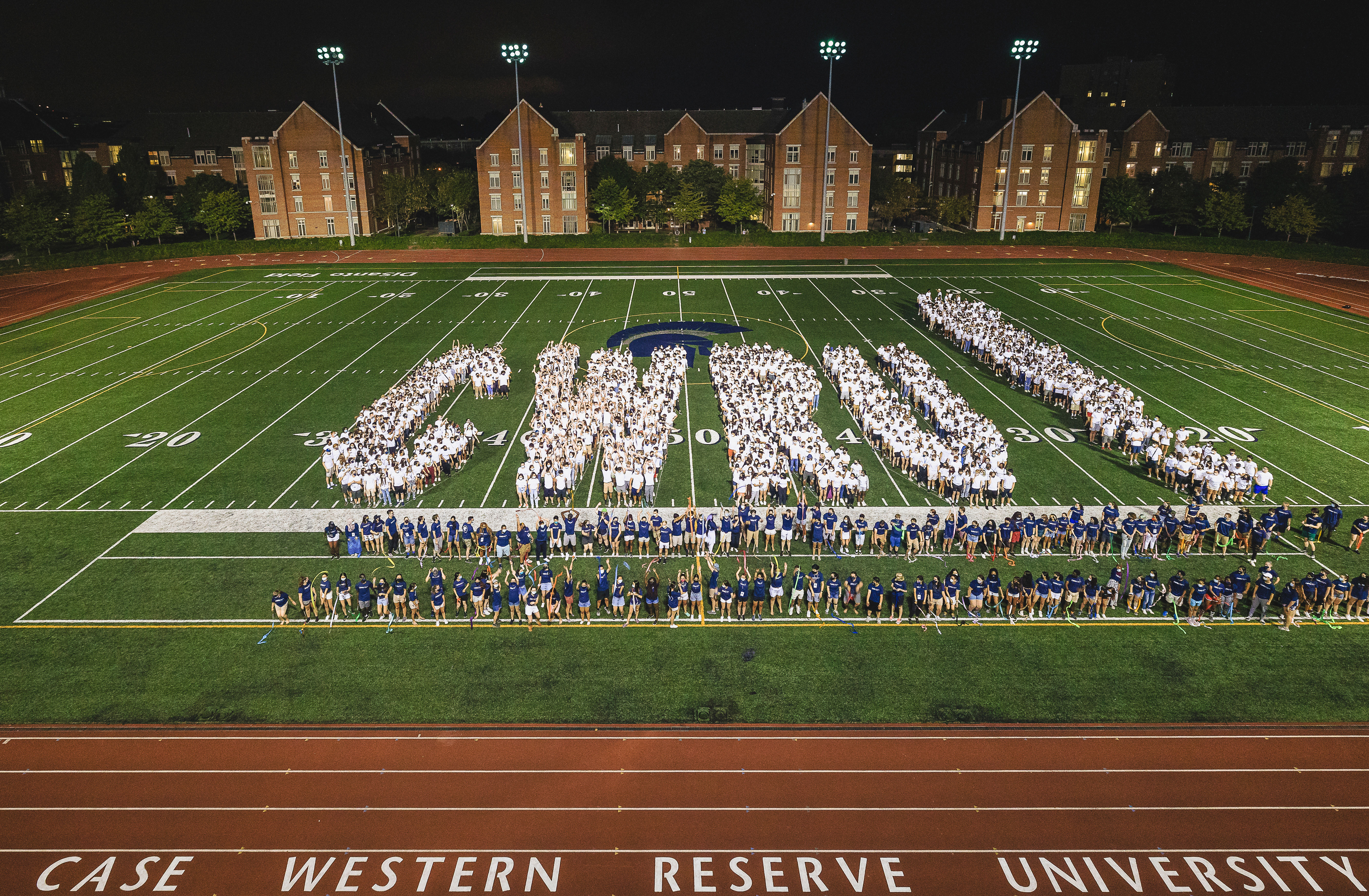 Groups of students line up to spell ‘CWRU!’ on the football field