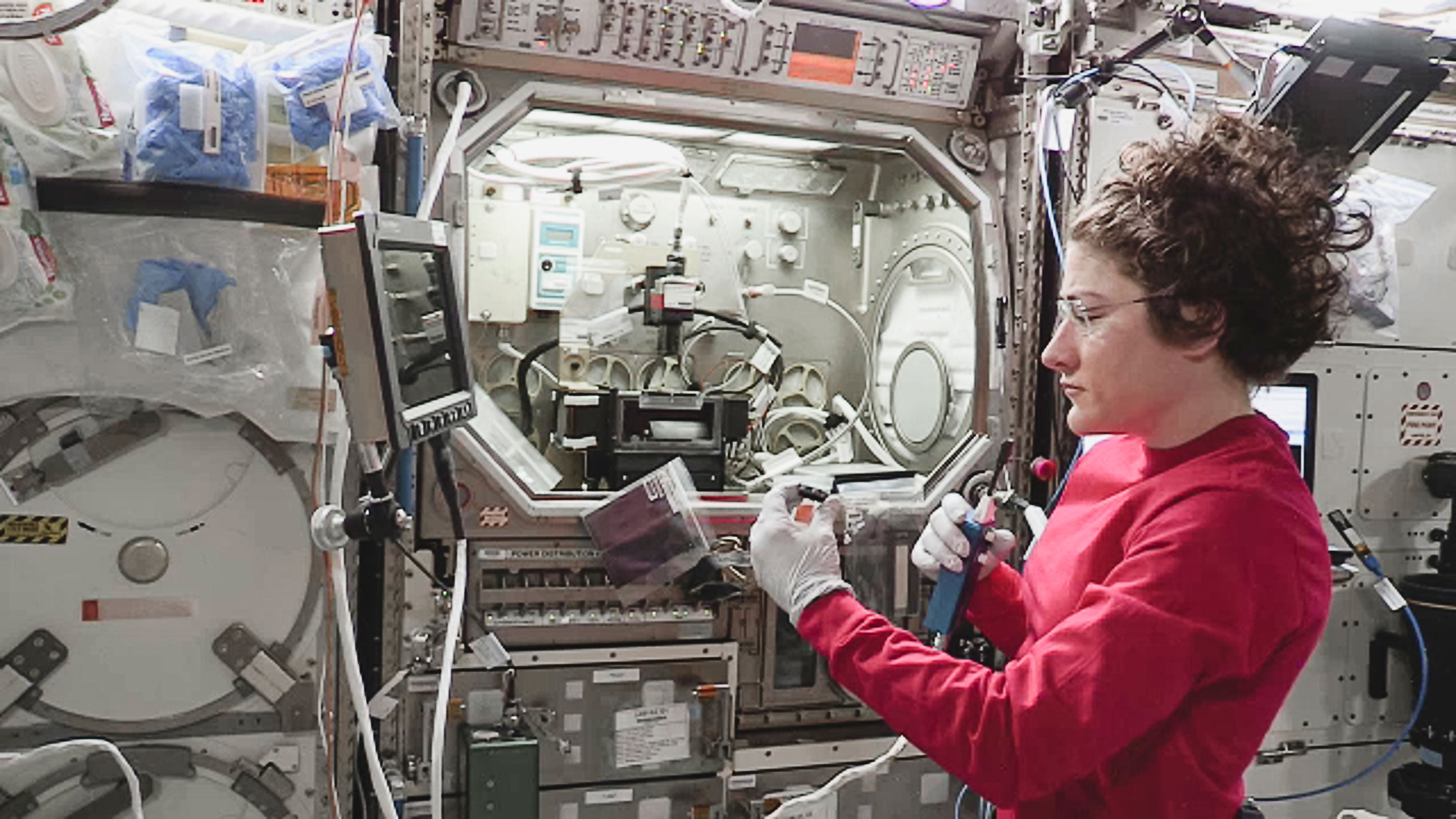 A woman working on a spacecraft in space