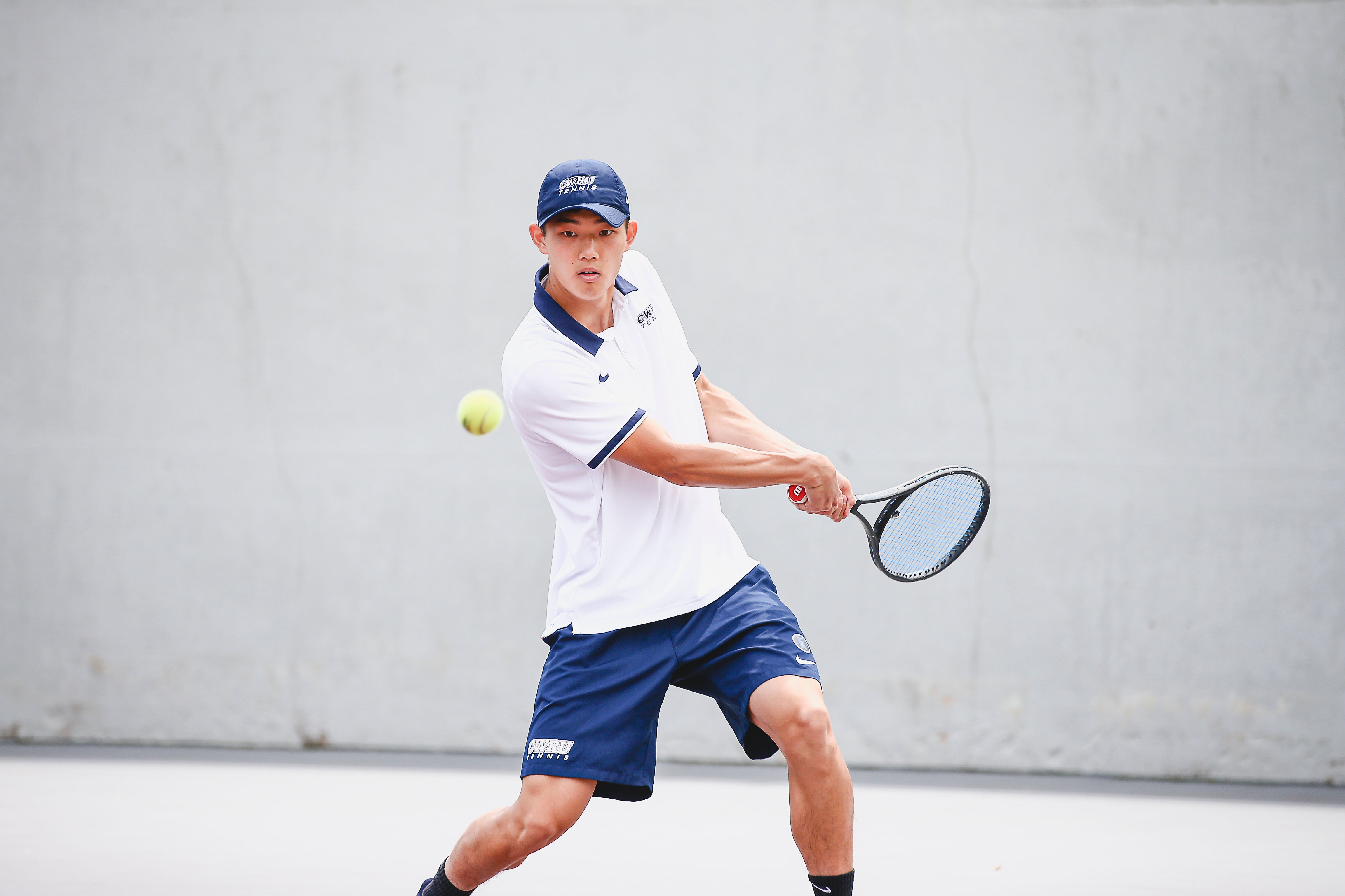 Matthew Chen hitting a tennis ball