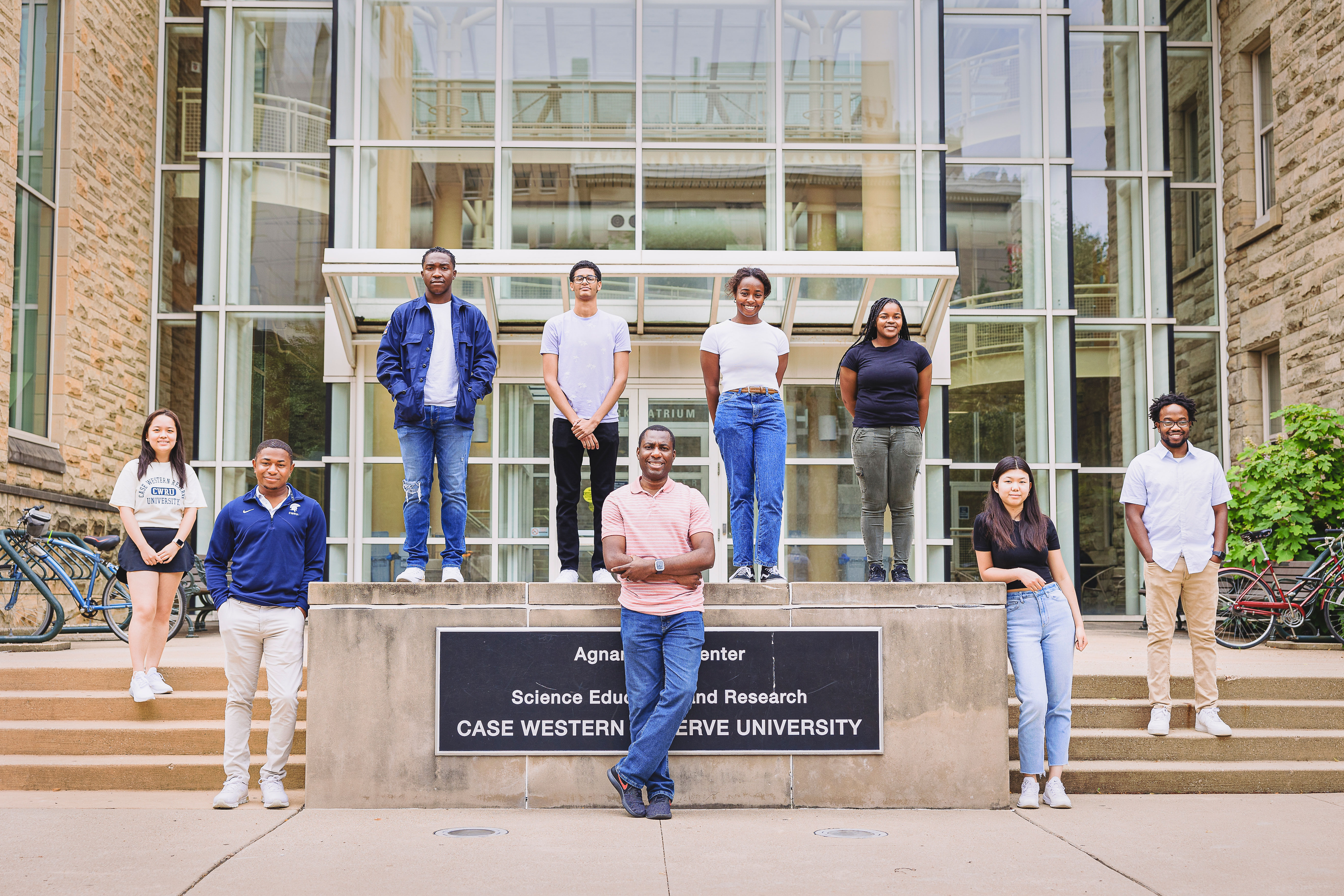 Nine students stand in front of the Agnar Pytts Center for Science Education and Research