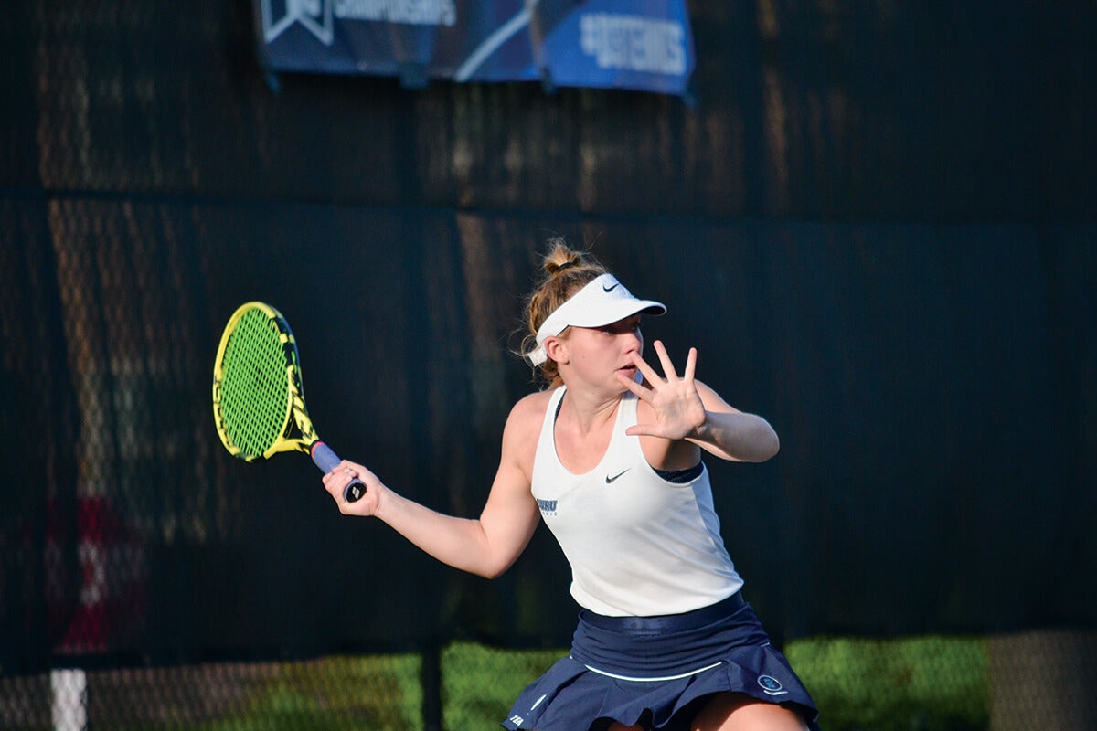 Photo of a student athlete playing tennis.