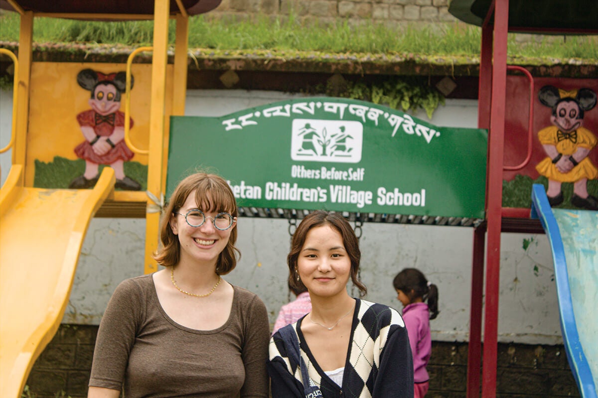 Photo of 2 undergraduates standing in front of playground equipment